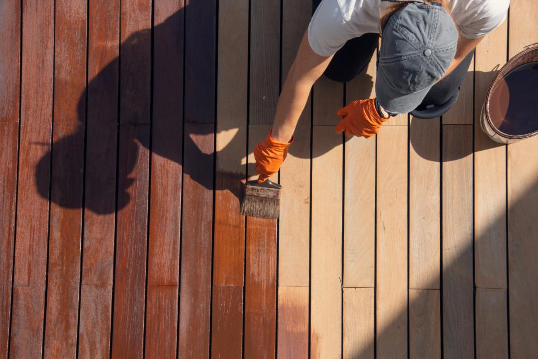 Man applying protective coat to an outdoor deck
