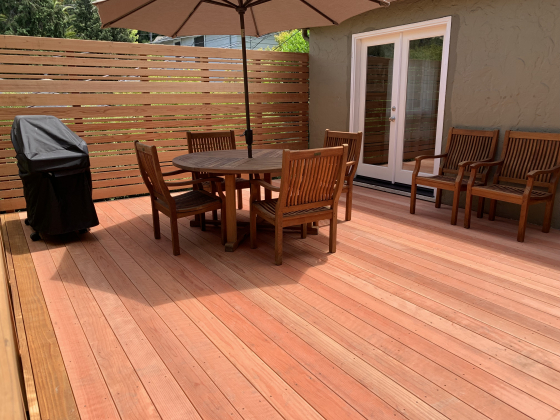 Beautiful new residential backyard deck with outdoor furniture and a bbq.