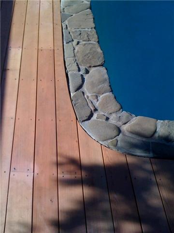 A closeup view of a residential deck built to lineup with the pools edge.