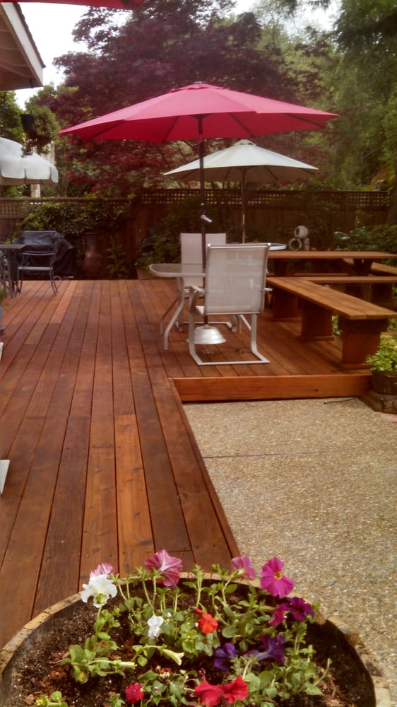 A backyard deck with built in seating as well as some outdoor furniture.