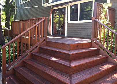 A backyard deck with stairs leading to the rest of the backyard.